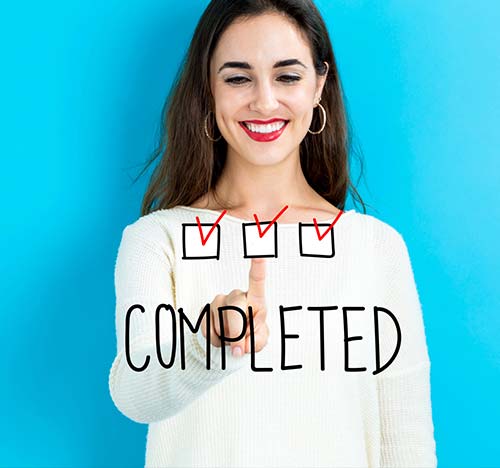 Young woman pointing at check boxes for a completed task.